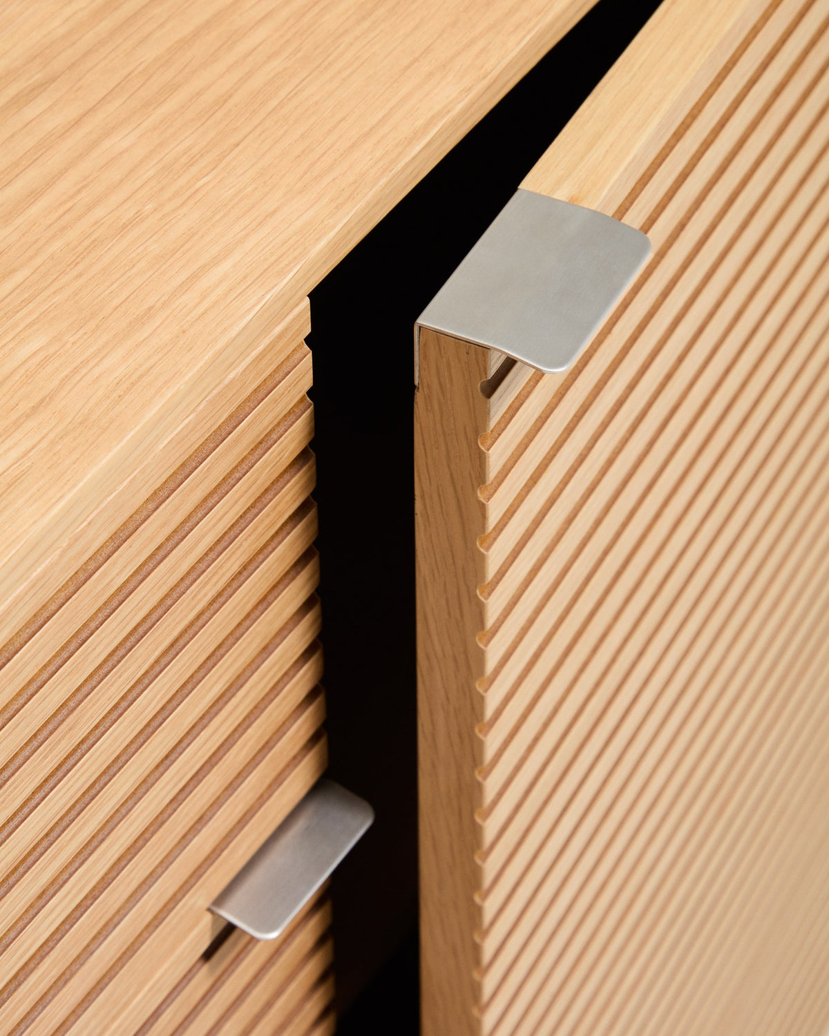 Braunes Sideboard Norlen mit vier Türen, zwei Schubladen und Eichenfurnier, abgerundete Ecken, Holzunterbau mit vier Beinen.