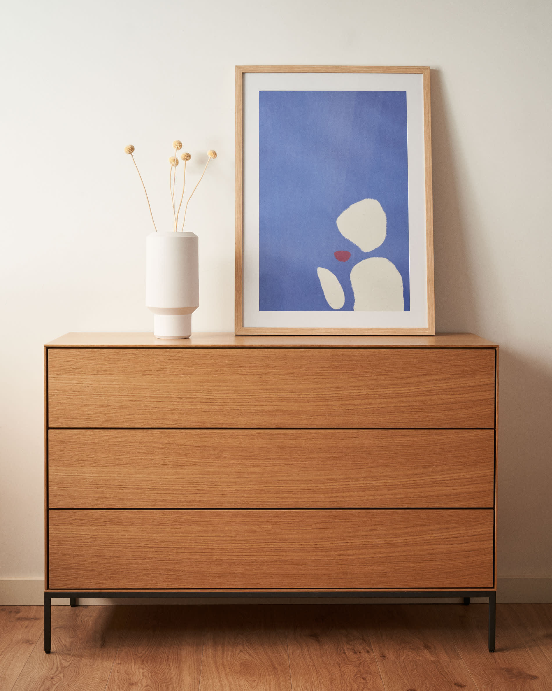 Die Vedrana Kommode kombiniert Eichenfurnier mit schwarzen Stahlbeinen, bietet 3 Schubladen und misst 110 x 75 cm. Stilvoll und praktisch.