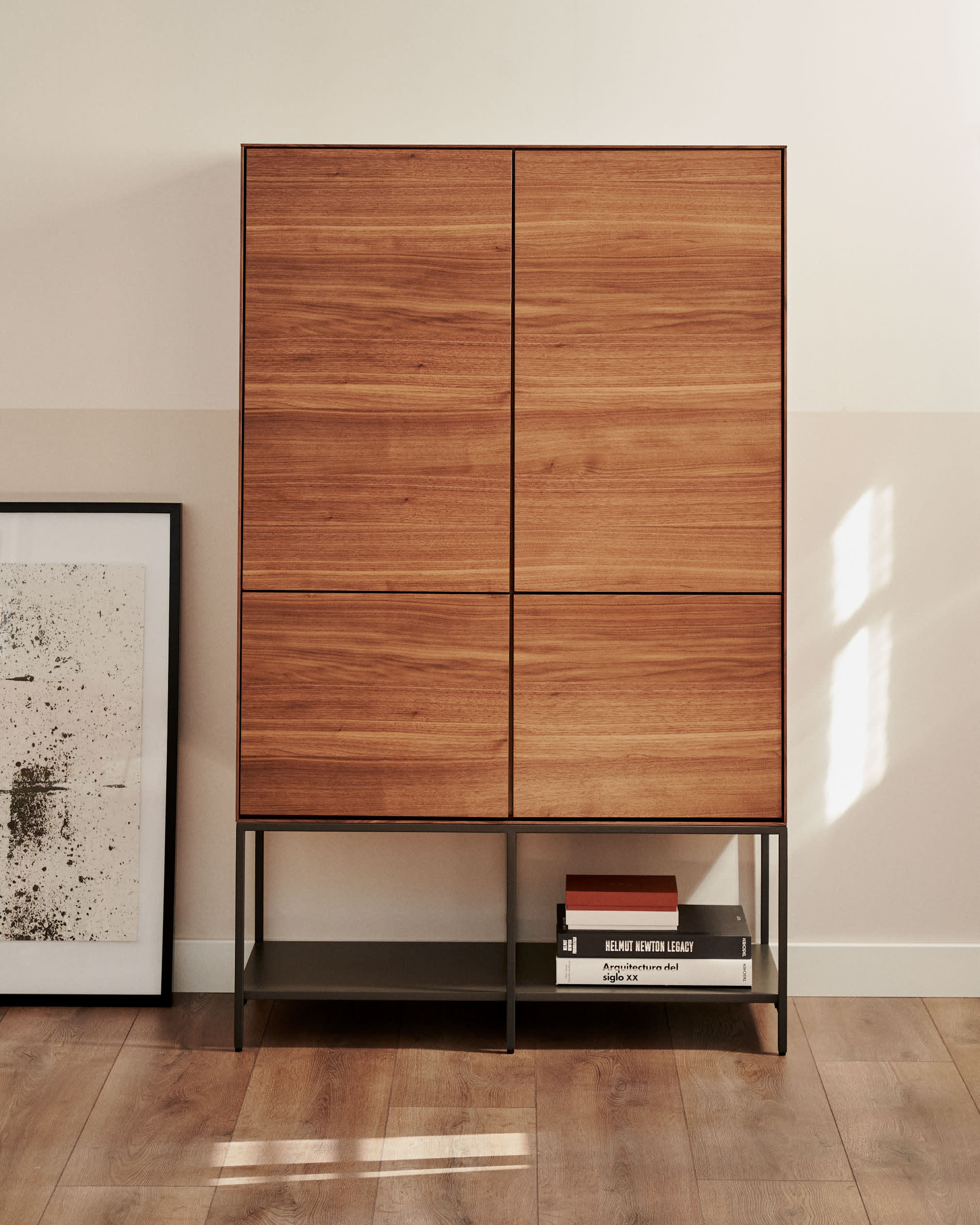 Das Vedrana Highboard kombiniert edles Nussholzfurnier mit schwarzen Stahlbeinen, bietet Stil und Funktionalität für Ihr Zuhause.