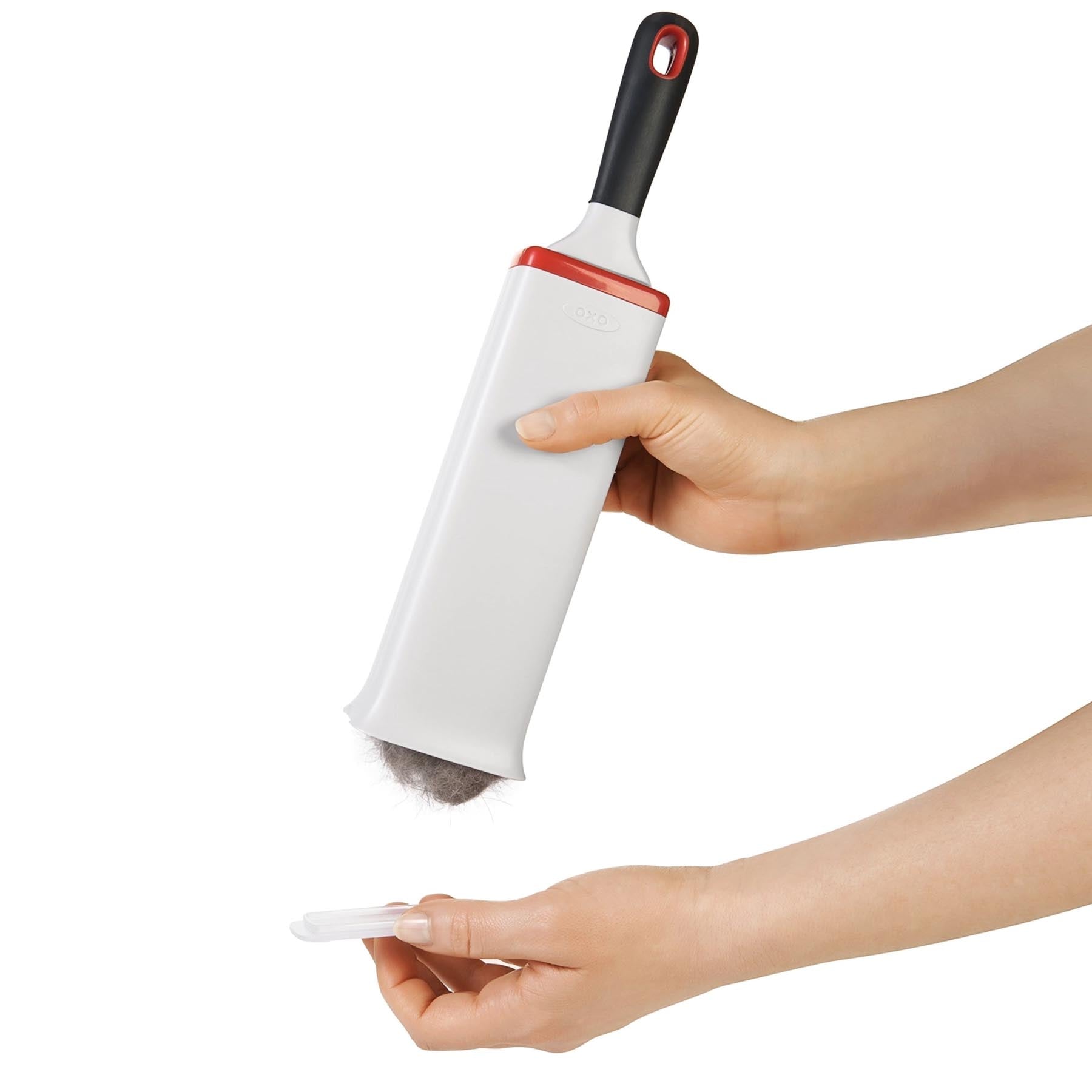 Praktische GG Flusenentferner Bürste in stilvollem Weiß-Orange von OXO, ideal zur schnellen Entfernung von Fusseln und Haaren von Möbeln.