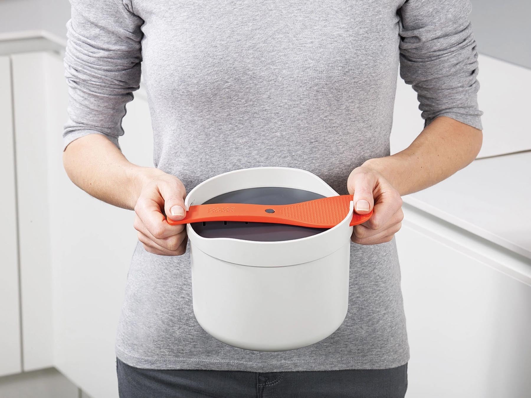 Stylischer M-Cuisine Reiskocher in Grau und Orange, ideal für die Zubereitung von Reis und anderen Beilagen, präsentiert von Joseph Joseph.