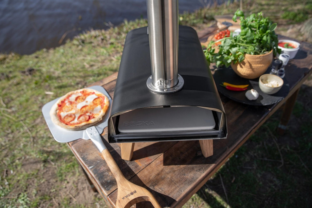 Schwarzer Pizzaofen für Pellets von Boska mit offener Feuertasse und Brennkammer, Grösse 69.9x36 cm, Höhe 72.5 cm.