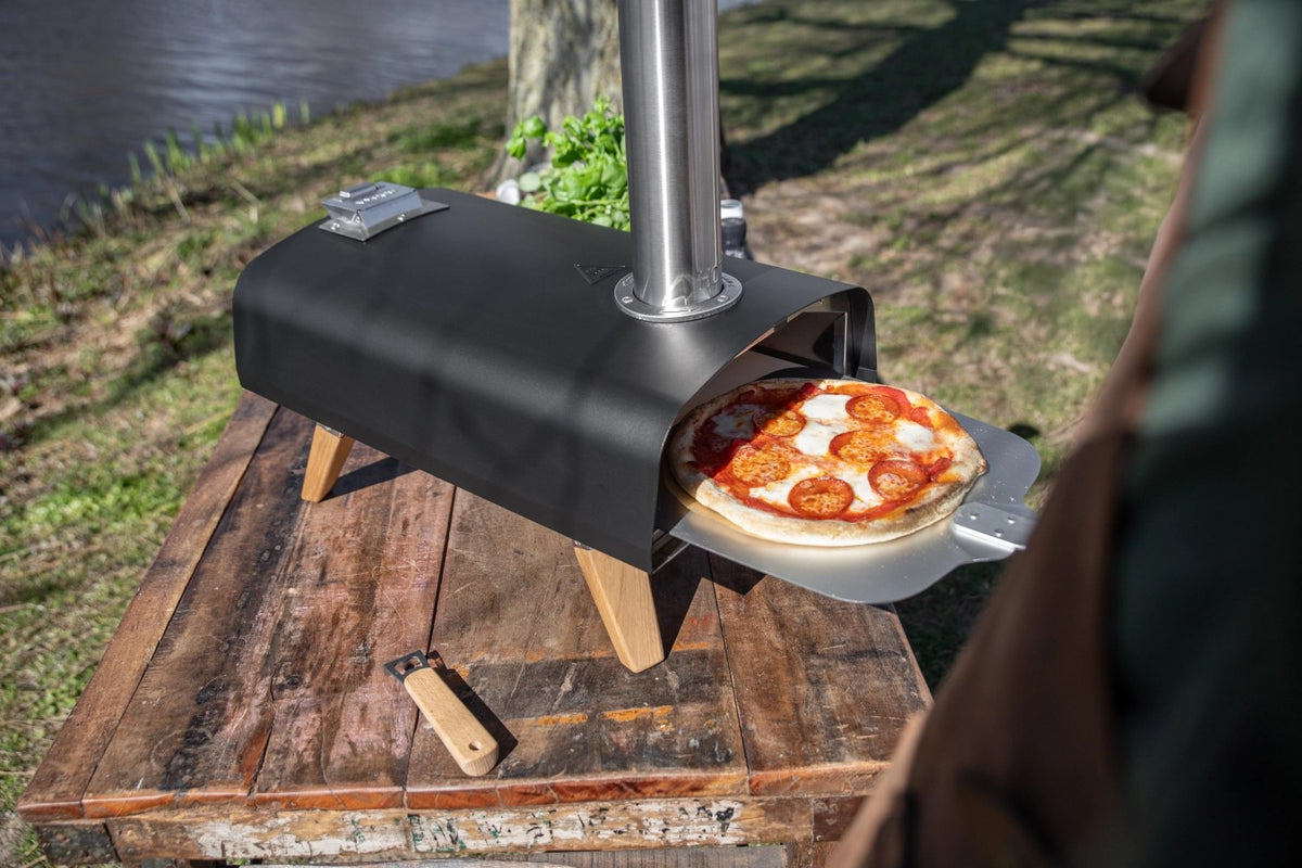 Schwarzer Pizzaofen für Pellets von Boska mit offener Feuertasse und Brennkammer, Grösse 69.9x36 cm, Höhe 72.5 cm.