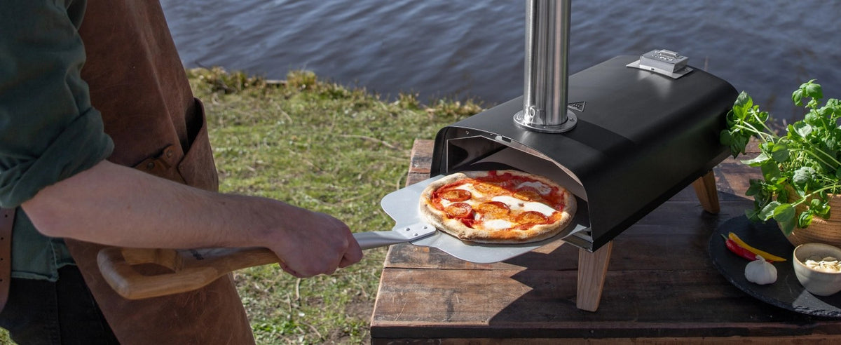Schwarzer Pizzaofen für Pellets von Boska mit offener Feuertasse und Brennkammer, Grösse 69.9x36 cm, Höhe 72.5 cm.