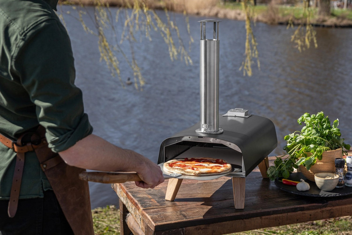 Schwarzer Pizzaofen für Pellets von Boska mit offener Feuertasse und Brennkammer, Grösse 69.9x36 cm, Höhe 72.5 cm.
