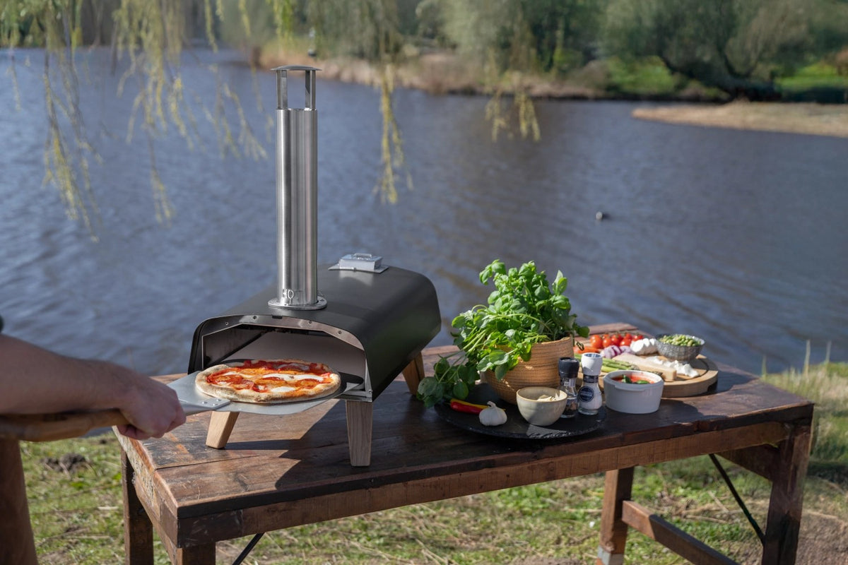 Schwarzer Pizzaofen für Pellets von Boska mit offener Feuertasse und Brennkammer, Grösse 69.9x36 cm, Höhe 72.5 cm.
