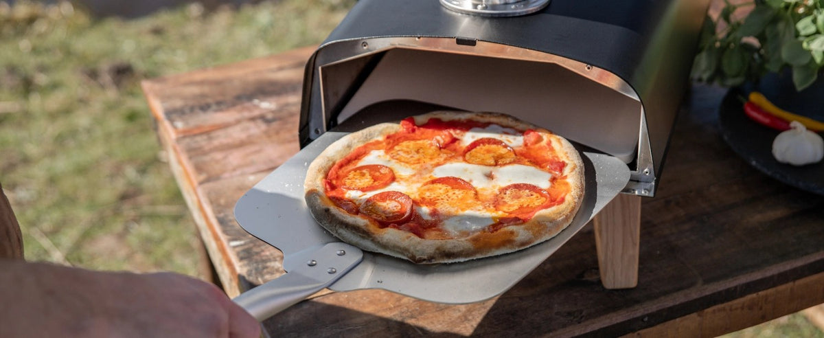 Schwarzer Pizzaofen für Pellets von Boska mit offener Feuertasse und Brennkammer, Grösse 69.9x36 cm, Höhe 72.5 cm.