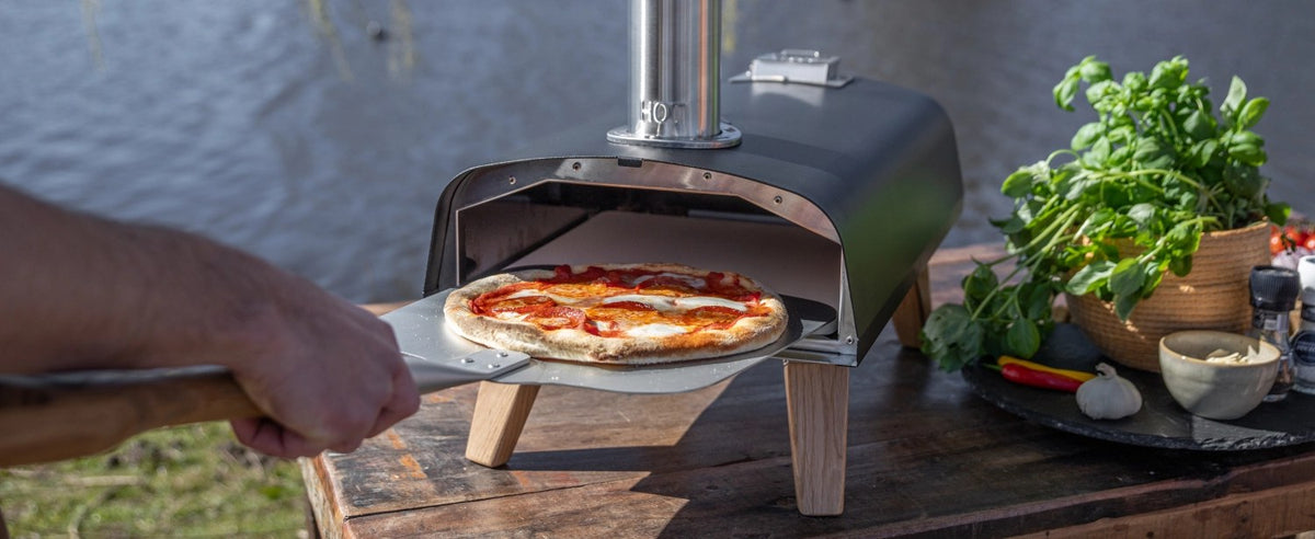 Schwarzer Pizzaofen für Pellets von Boska mit offener Feuertasse und Brennkammer, Grösse 69.9x36 cm, Höhe 72.5 cm.