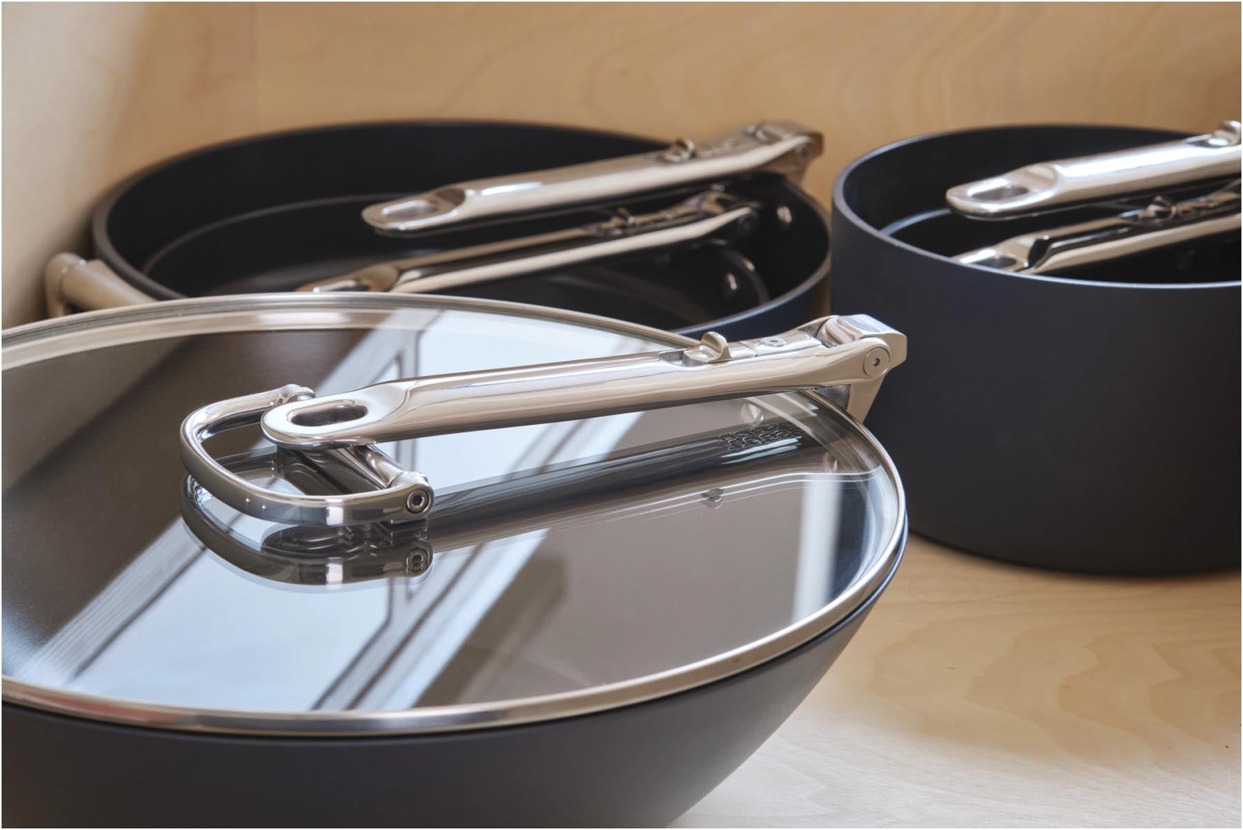 Moderner Wok aus Edelstahl mit praktischem Klappgriff und antihaftbeschichtetem Deckel, perfekt für kreative Kochabenteuer.