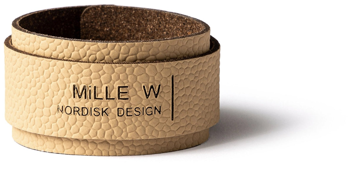 Beiger Serviettenring aus dem Sortiment Servietten von MiLLE W NORDISK DESIGN, quadratische Form, Masse 7x7x2.5 cm, auf hellem Untergrund platziert.