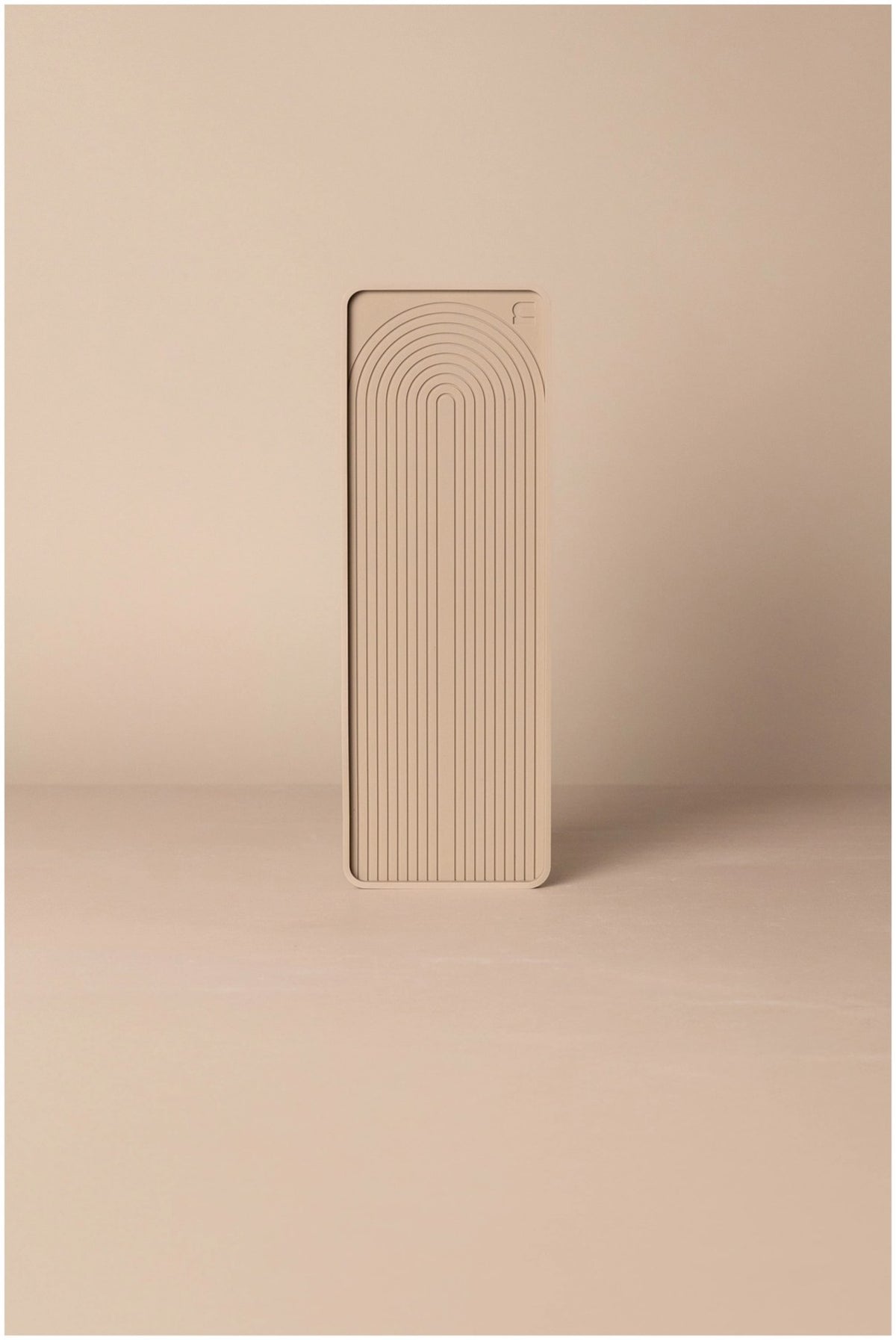 Beige Abtropfmatte aus Silikon, 28x10 cm, mit strukturierter Oberfläche und nordischem Bogenmuster, liegend auf einer Küchenarbeitsfläche.