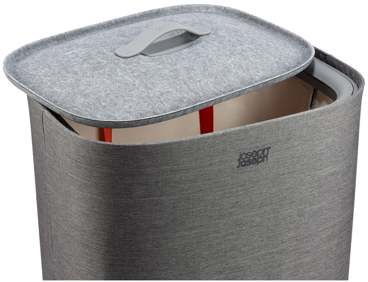 Grauer Wäschetrennkorb Tota One 60l von Joseph Joseph mit seitlichem Filzdeckel und herausnehmbarer Tragetasche für die Wäsche.