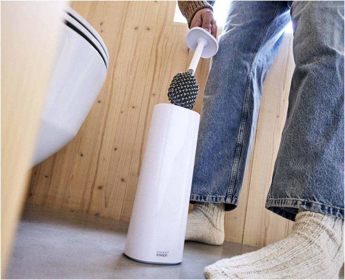 Weisse WC-Bürste Flex TriBlade von Joseph Joseph mit passendem geschlossenem Halter, schlanke Form, glänzende Oberfläche, freistehend im Badezimmer.
