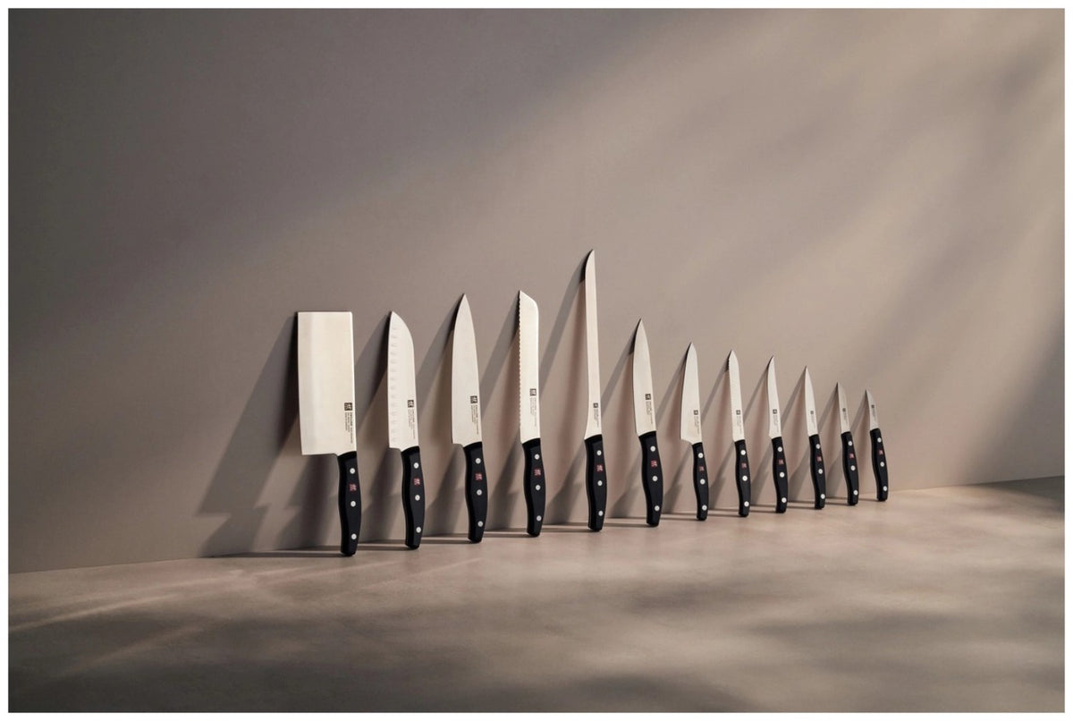 Zwilling Signature Schälmesser mit 6cm langer, gebogener Klinge aus Edelstahl und ergonomischem Griff im Drei-Nieten-Design.