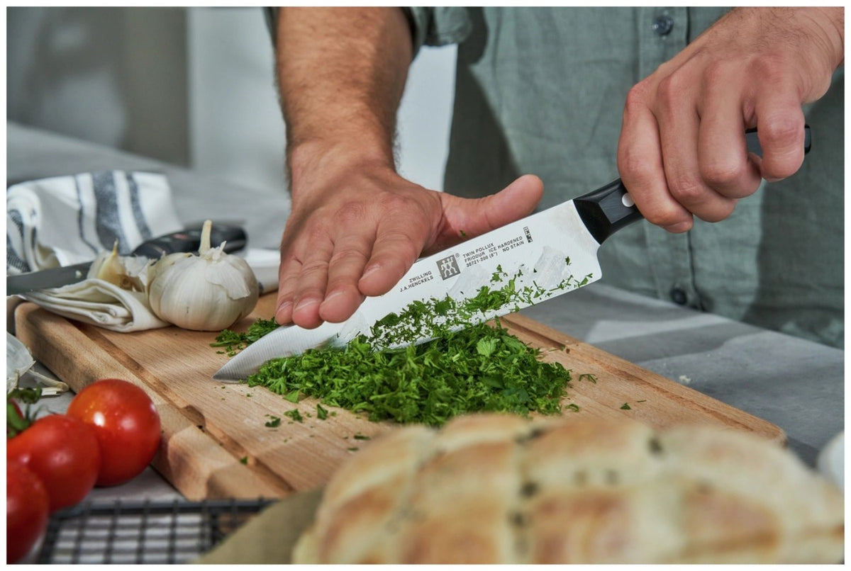 Zwilling Signature Kochmesser mit 20 cm langer Edelstahlklinge und schwarzem Griff im Drei-Nieten-Design, freigestellt fotografiert.