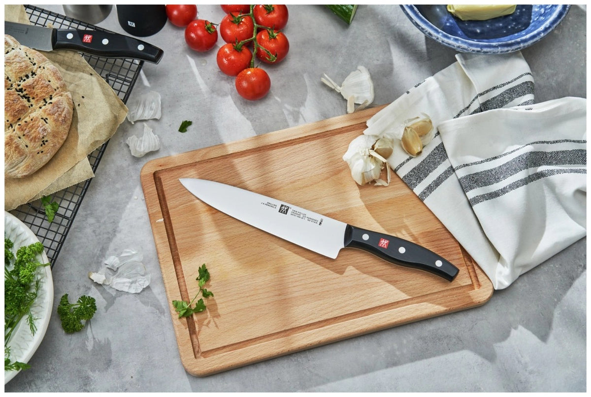 Zwilling Signature Kochmesser mit 20 cm langer Edelstahlklinge und schwarzem Griff im Drei-Nieten-Design, freigestellt fotografiert.