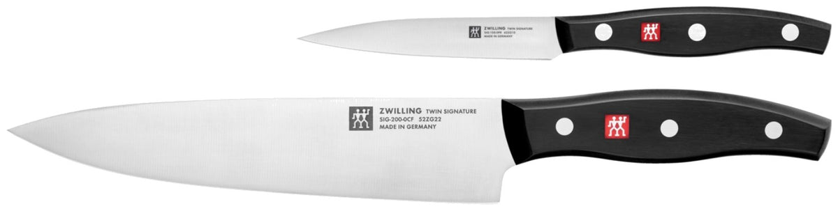 Zwei Küchenmesser von Zwilling: ein Schälmesser und ein Kochmesser mit Edelstahlklinge und Griff im Drei-Nieten-Design, nebeneinander liegend.