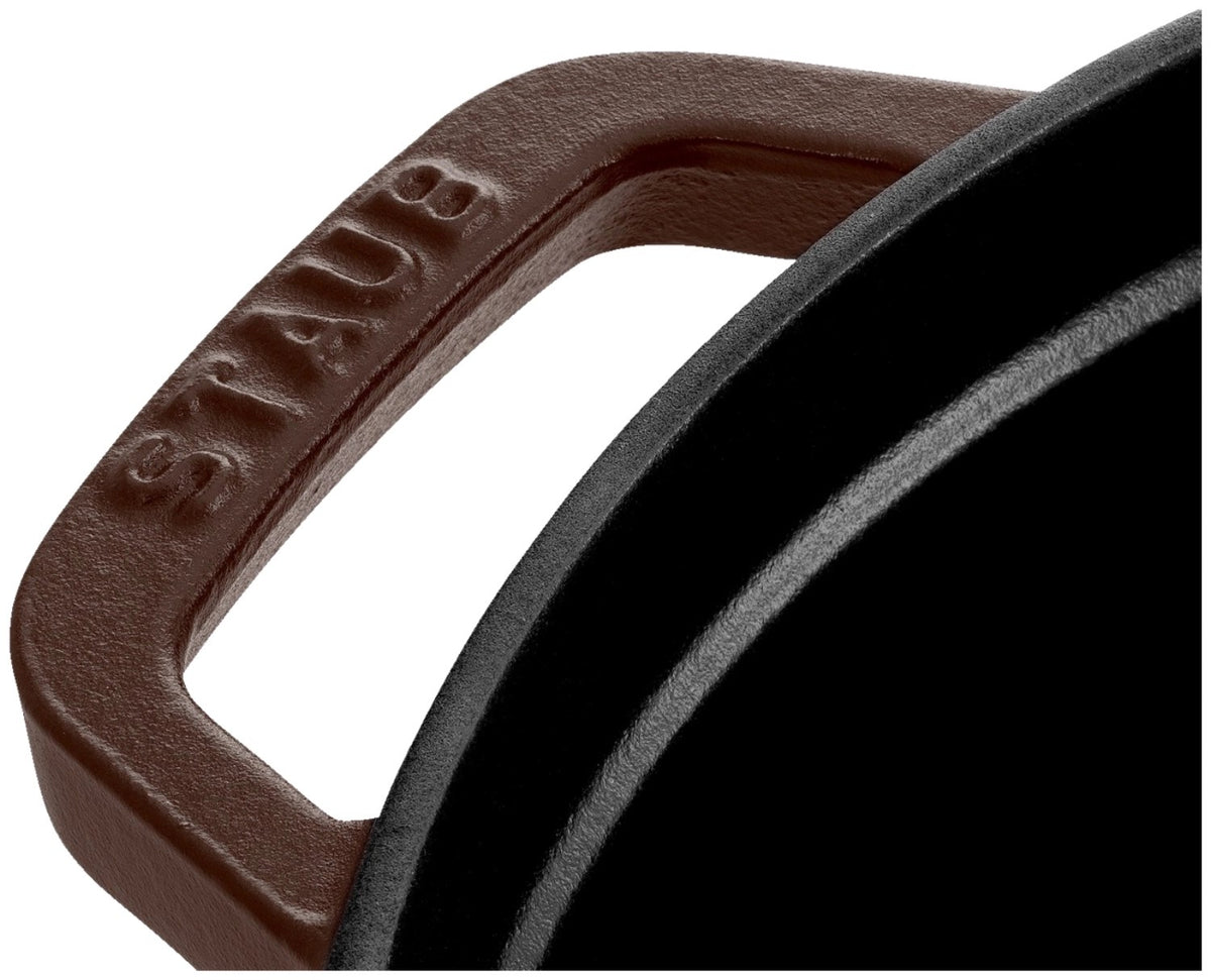 Runde Staub Cocotte aus Gusseisen in der Farbe Chocolat, 18 cm Durchmesser, mit Deckel und Griff, auf neutralem Hintergrund fotografiert.