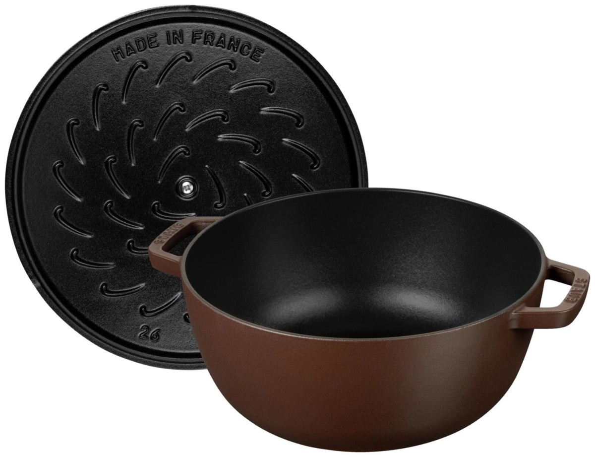 Braune gusseiserne Cocotte mit Deckel in ovaler bzw. runder Form, glänzend emaillierte Oberfläche, seitliche Grifflaschen am Topfkörper.