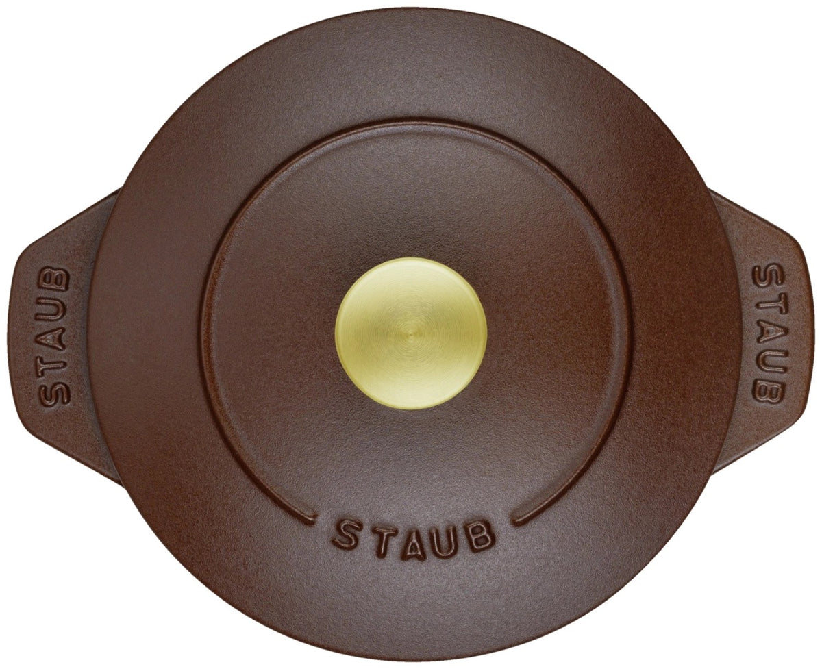Braune Cocotte aus Gusseisen mit Deckel, rund, 16 cm Durchmesser, matte Chocolat-Farbe, Staub Kochgeschirr auf hellem Hintergrund.
