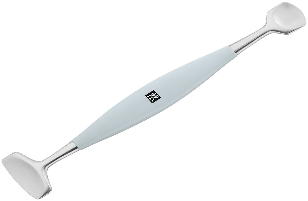 Silberfarbenes Facial Pore Refiner Tool aus Edelstahl mit zwei funktionalen Enden für die Gesichtspflege, liegend fotografiert.