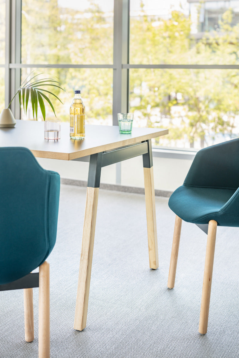 Eleganter Esstisch Ogi W PLD12P mit robusten Holzbeinen und einer hellen Tischplatte, perfekt für moderne Wohnräume.
