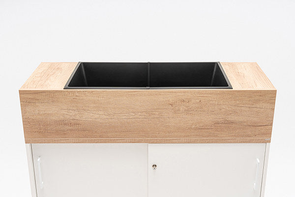 Blumentopf-Aufsatz aus Spanplatte in Honigeiche mit schwarzem Kunststoffeinsatz, montiert auf einem Büroschrank der Serie Standard.
