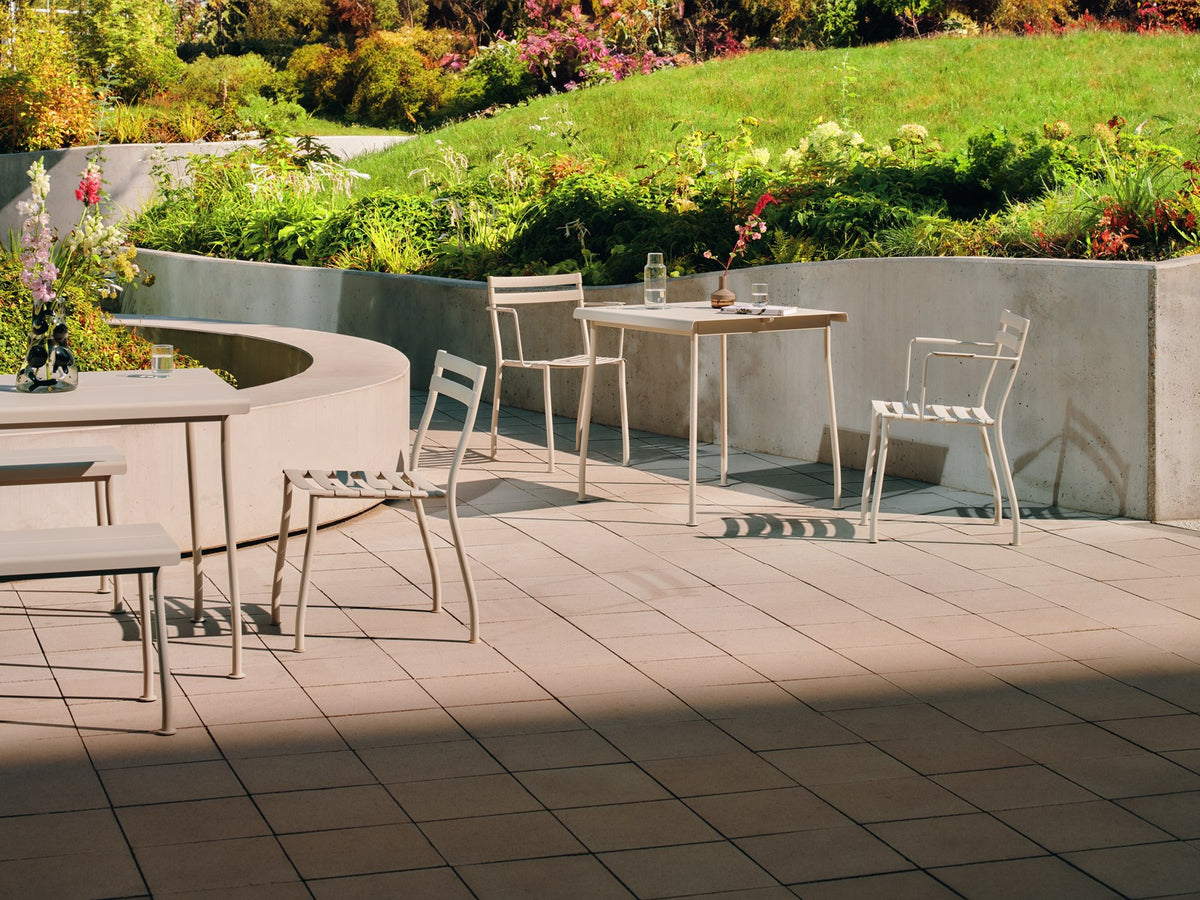 Zwei stapelbare Gartenstühle Flaner von Mdd aus verzinktem, pulverbeschichtetem Stahl in Türkis matt mit schwarzen Kunststofffüssen.