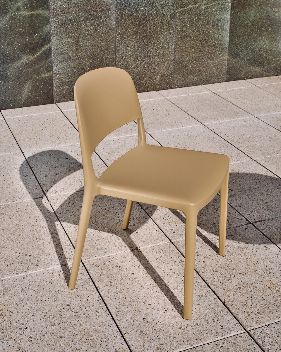Gelber Gartenstuhl Blendy aus Polypropylen mit stapelbarer Konstruktion, schlichte Form, Kunststoffschale und vier Beine, Aussenbereich.