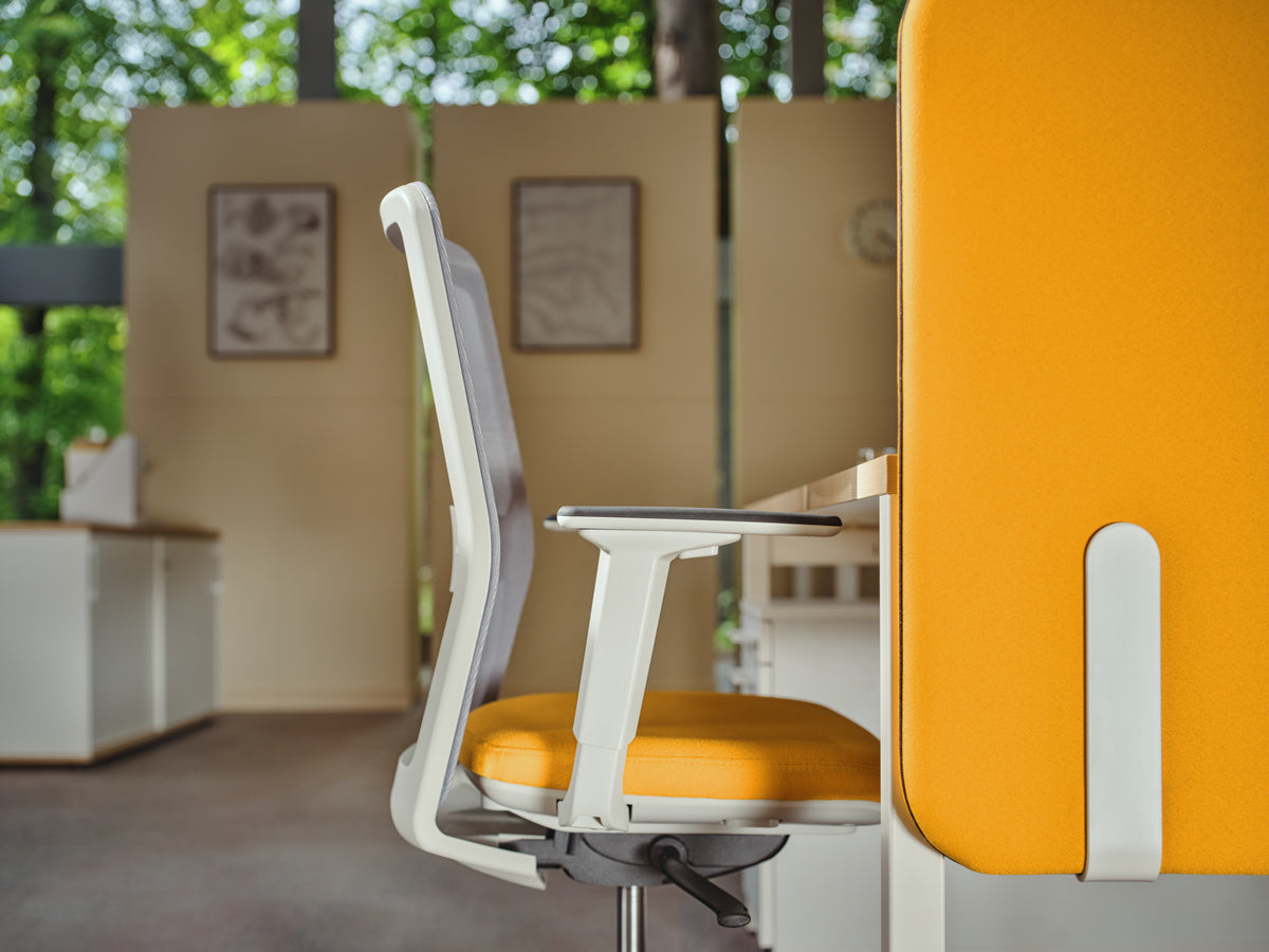 Orangefarbener Bürostuhl mit grauer Mesh-Rückenlehne, gepolstertem Sitz, Fünfstern-Fussgestell aus Kunststoff und Rollen für weiche Böden.