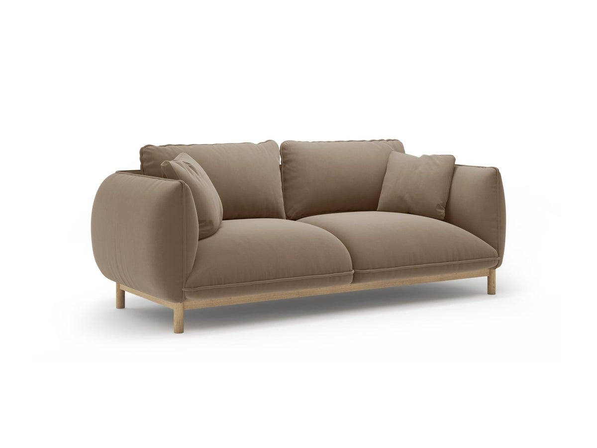 Ada 2er Sofa von Micadoni in Mandel beige mit gepolstertem Velours-Bezug, geschwungener Rückenlehne und sichtbaren Buchenholzbeinen.