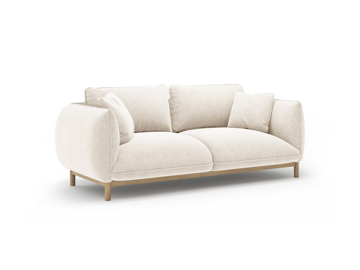 Ada 2er Sofa von Micadoni in Mandel beige mit gepolstertem Velours-Bezug, geschwungener Rückenlehne und sichtbaren Buchenholzbeinen.
