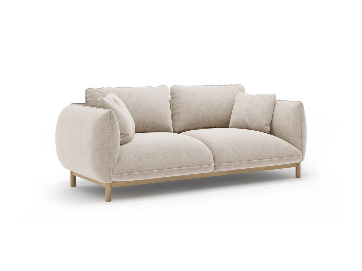 Ada 2er Sofa von Micadoni in Mandel beige mit gepolstertem Velours-Bezug, geschwungener Rückenlehne und sichtbaren Buchenholzbeinen.