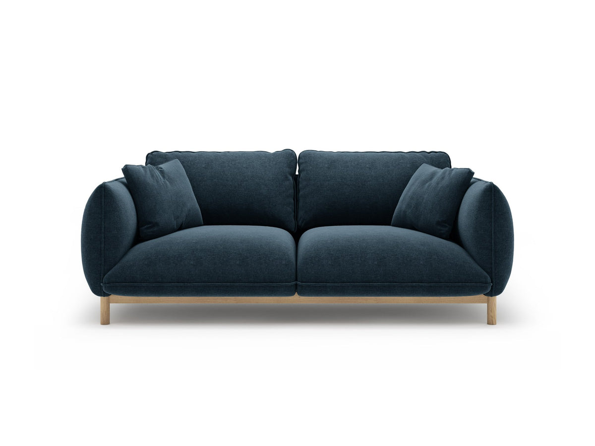 Ada 2er Sofa von Micadoni in Mandel beige mit gepolstertem Velours-Bezug, geschwungener Rückenlehne und sichtbaren Buchenholzbeinen.