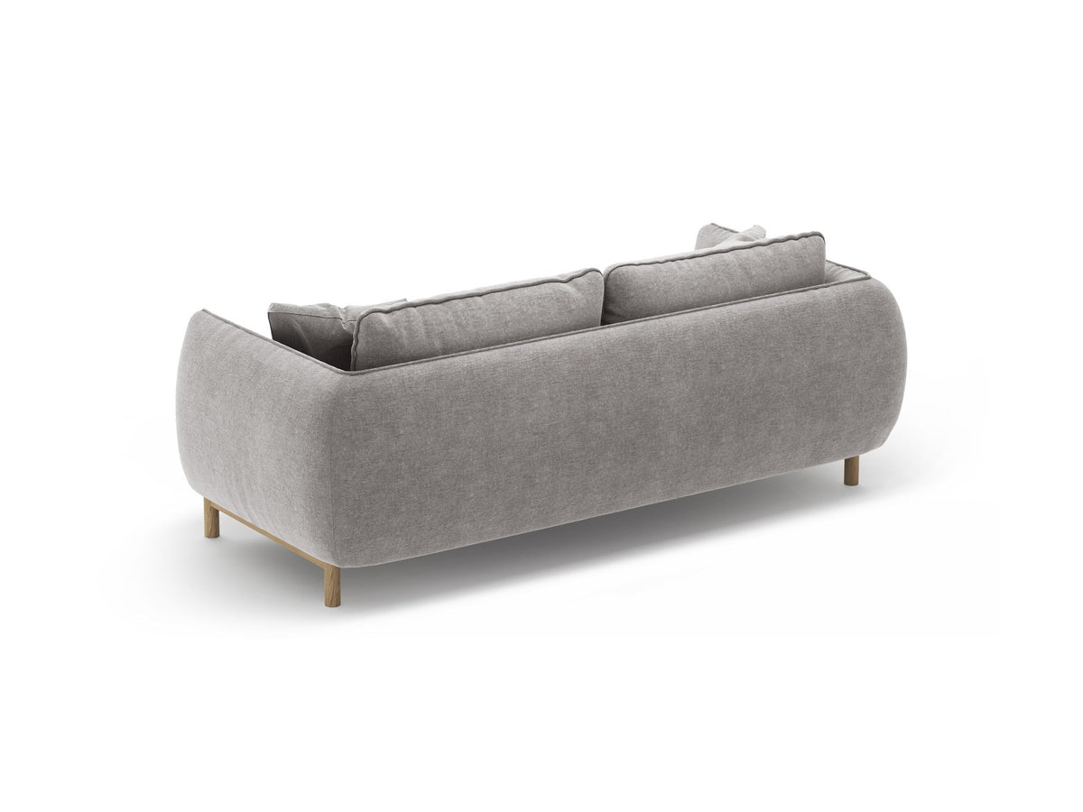 Ada 2er Sofa von Micadoni in Mandel beige mit gepolstertem Velours-Bezug, geschwungener Rückenlehne und sichtbaren Buchenholzbeinen.