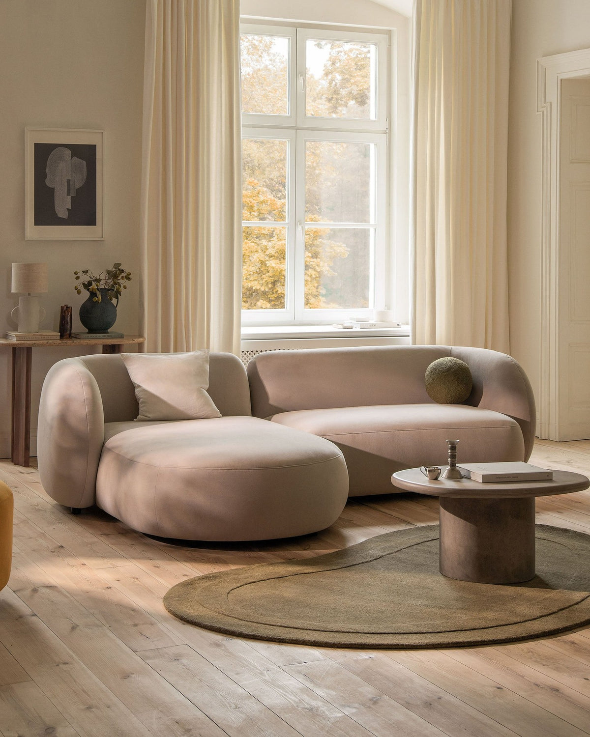 Weisses 4er Sofa Kate von Micadoni mit strukturiertem Bouclé-Stoff, schwarzen Kunststoffbeinen und breiter Sitzfläche.