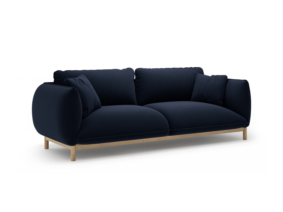 Dreisitzer-Sofa Ada von Micadoni mit geschwungener Form, Casino-Velours-Bezug in Mandel Beige und Buchenholzbeinen.