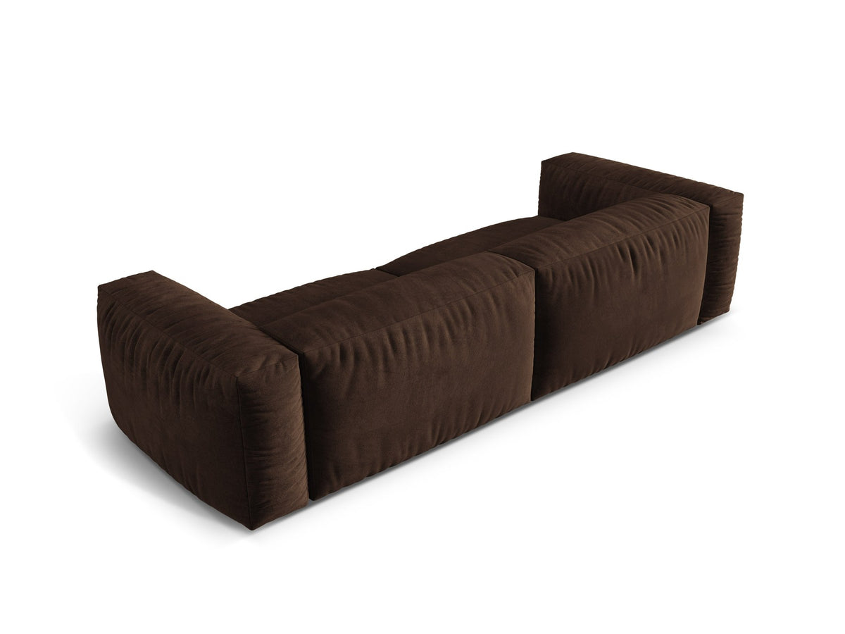 Modulares 4er Sofa Martina XL von Micadoni in Schokolade, Veloursstoff Vogue, schwarze Kunststoffbeine, im Wohnzimmer platziert.
