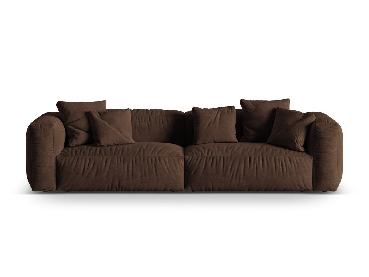 Modulares 4er Sofa Martina XL von Micadoni in Schokolade, Veloursstoff Vogue, schwarze Kunststoffbeine, im Wohnzimmer platziert.
