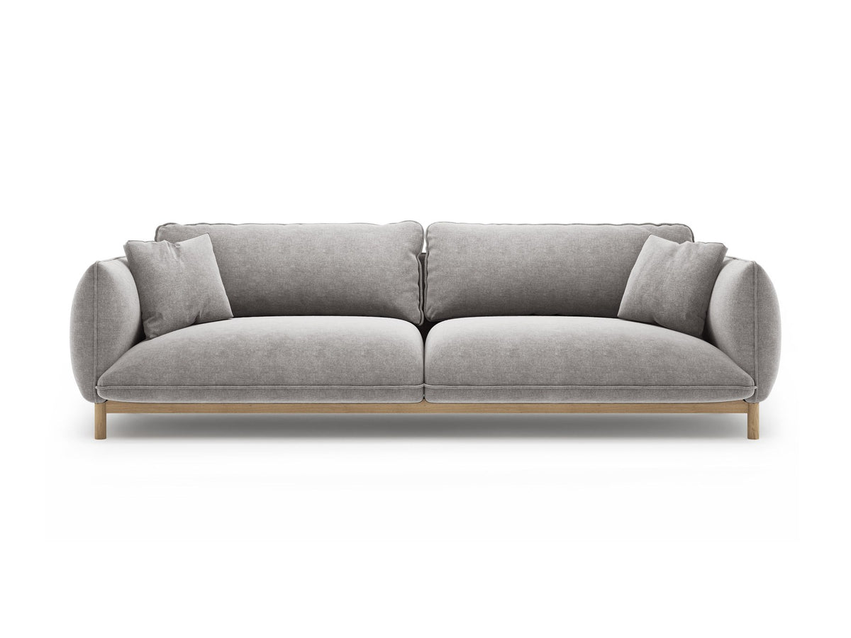 Vierersofa Ada von Micadoni in Mandel beige mit Casino-Stoffbezug, gerundeten Armlehnen und sichtbarem Buchenholzgestell auf Holzbeinen.