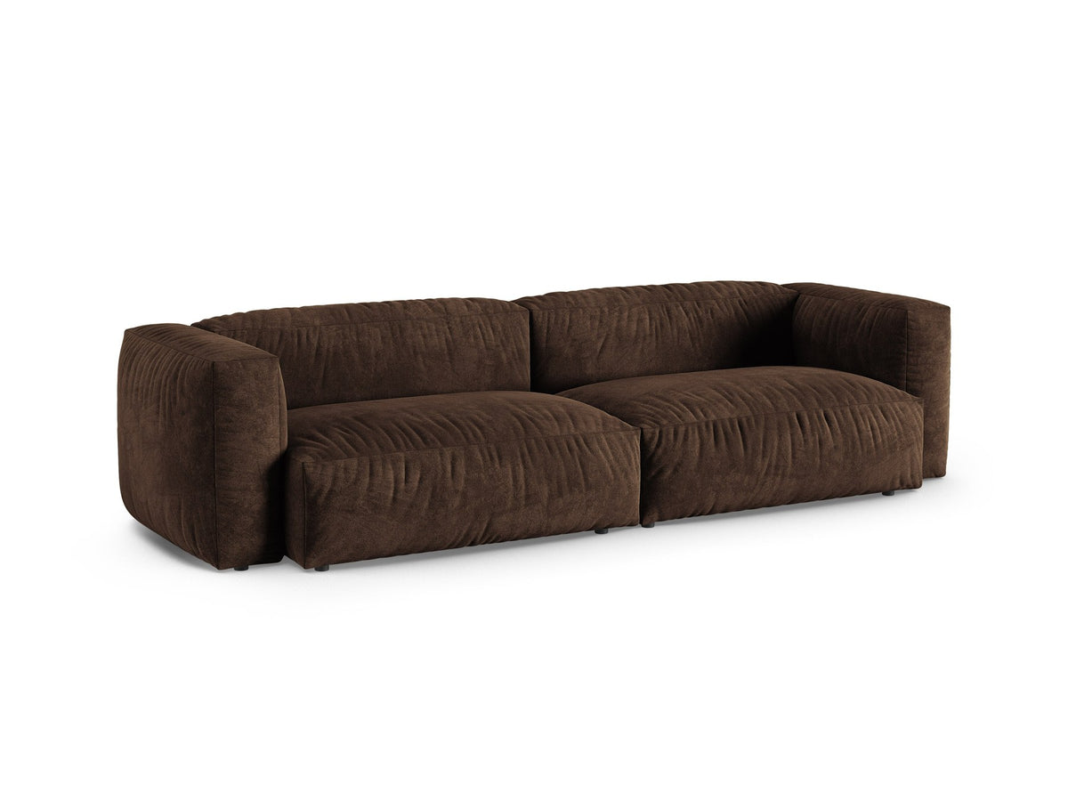 Modulares 4er Sofa Martina XL von Micadoni in Schokolade, Veloursstoff Vogue, schwarze Kunststoffbeine, im Wohnzimmer platziert.