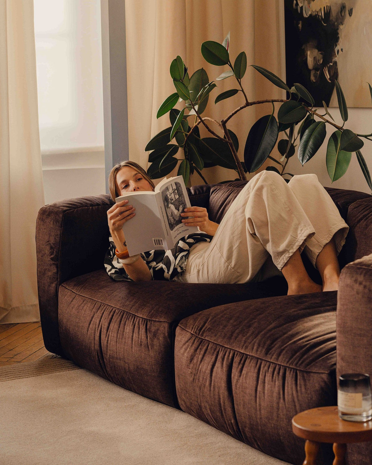 Modulares 4er Sofa Martina XL von Micadoni in Schokolade, Veloursstoff Vogue, schwarze Kunststoffbeine, im Wohnzimmer platziert.