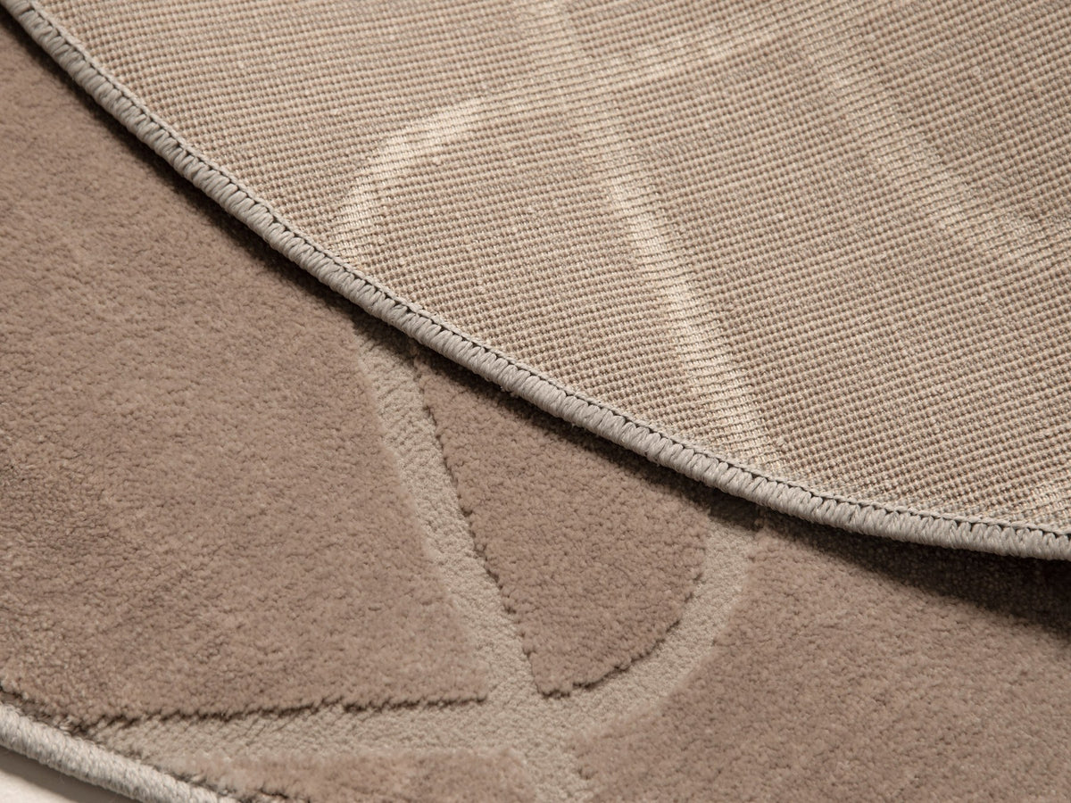 Runder beiger Teppich Tana von Micadoni aus einer Polypropylen-Polyester-Mischung mit dichtem, strukturiertem Flor und sauberen Kanten.