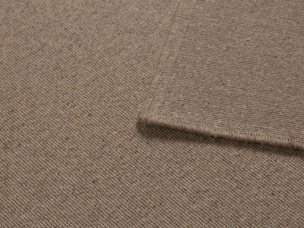 Dunkelbeiger Wollteppich Terra von Micadoni, rechteckig, 300x200cm, mit dichtem Flor und sauber verarbeiteten Kanten.