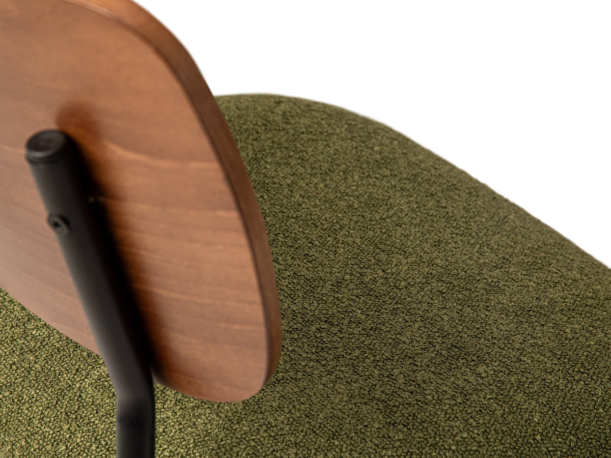 Beiger Samtstuhl mit gepolstertem Sitz aus Bouclé-Stoff, ergonomischer Rückenlehne aus Buchenholz und schwarzen Stahlbeinen im Esszimmer.