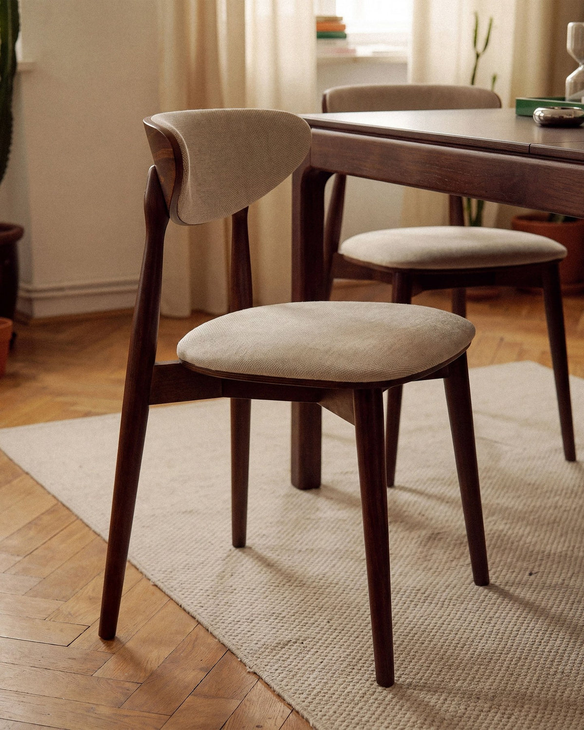 Foto des Rina Stuhls von Micadoni mit samtigem Bezug in Mandel Beige, gepolsterter Rückenlehne und Beinen aus amerikanischem Nussbaum.