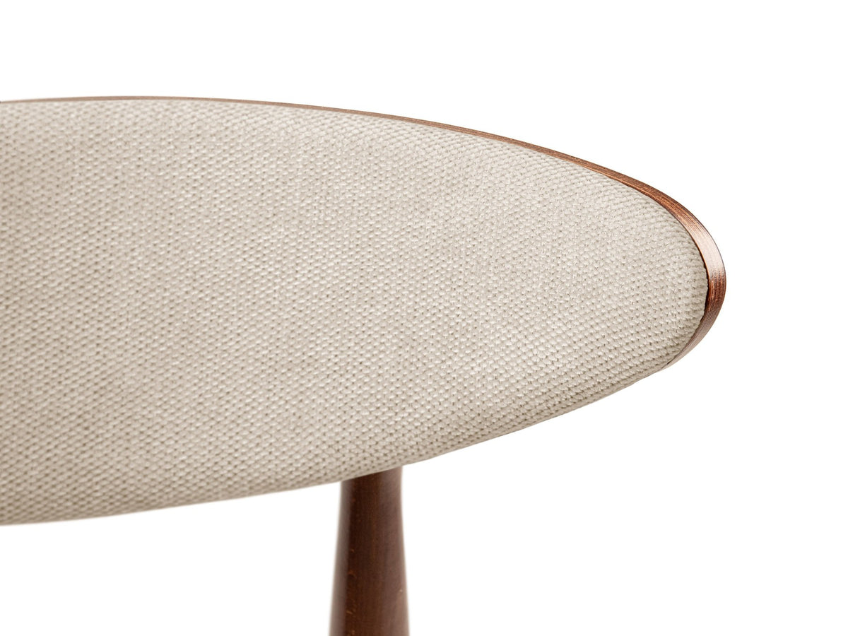 Samtiger Stuhl Rina von Micadoni in Mandel beige mit rundem gepolstertem Rücken und Beinen aus Nussbaumholz, Ansicht von vorne.