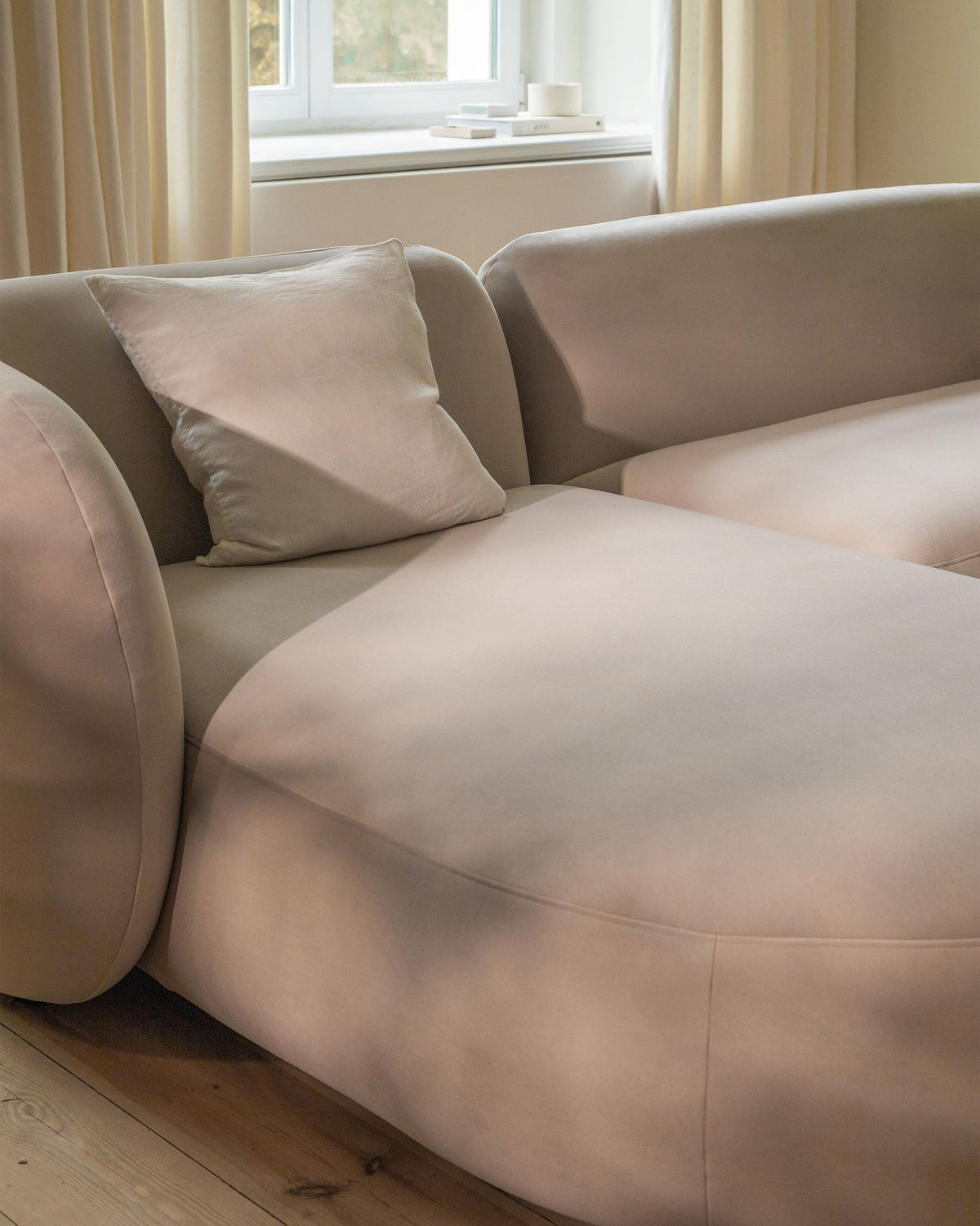 Produktfoto des weissen Kate Ecksofas links von Micadoni mit Bouclé-Stoffbezug, schwarzen Kunststoffbeinen und niedriger Rückenlehne.
