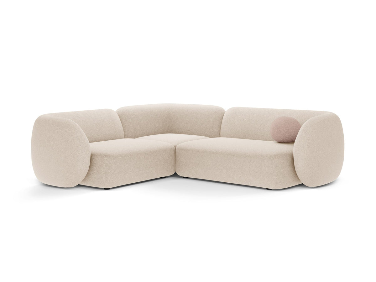 Weisses Ecksofa links Kate von Micadoni mit Bouclé-Stoff Baloo, schwarzen Kunststoffbeinen und niedriger Rückenlehne im Wohnraum.