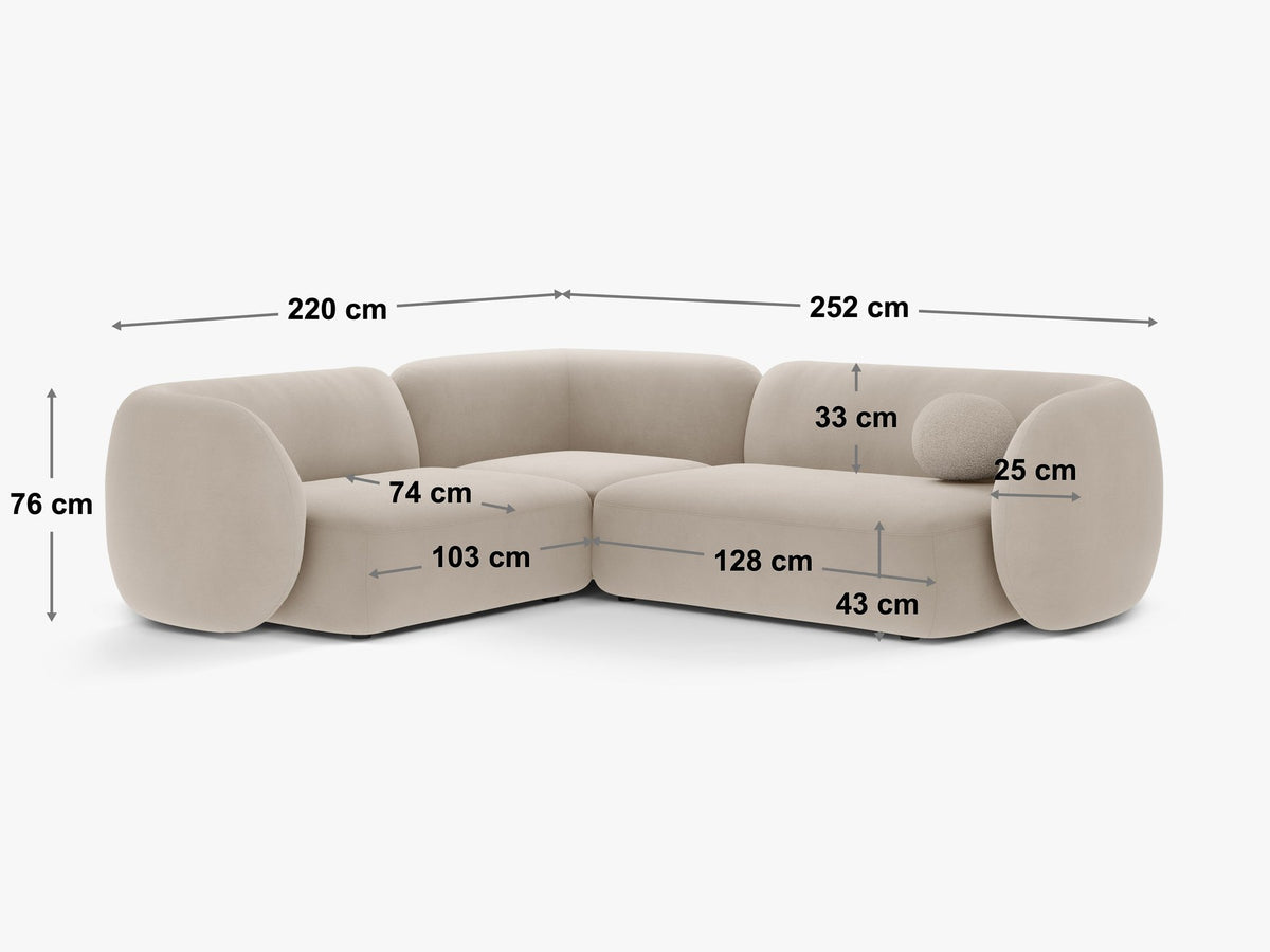 Weisses Ecksofa links Kate von Micadoni mit Bouclé-Stoff Baloo, schwarzen Kunststoffbeinen und niedriger Rückenlehne im Wohnraum.